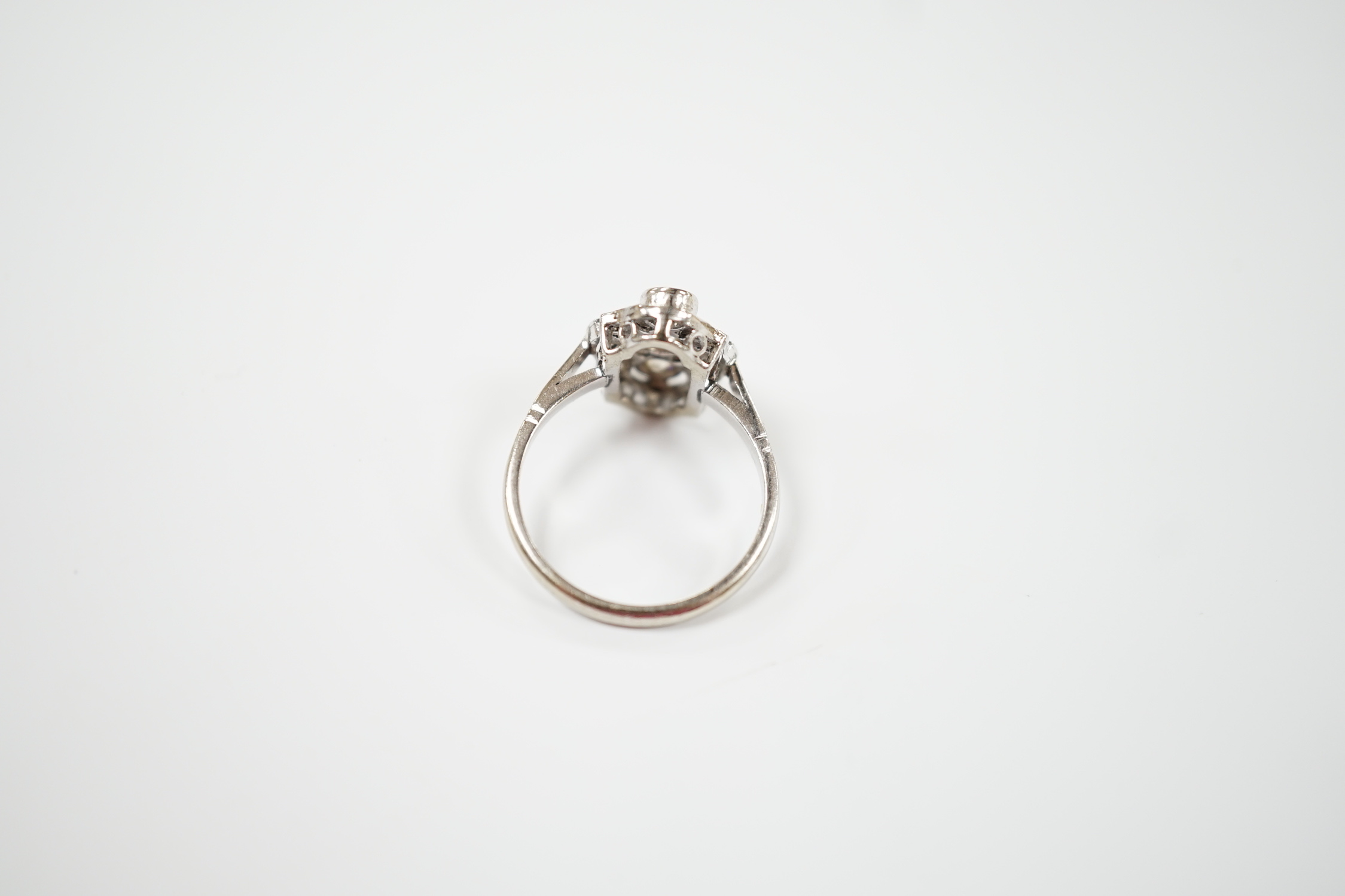 An Art Deco pierced white metal and millegrain set diamond cluster ring, size L, gross weight 3.2 grams.